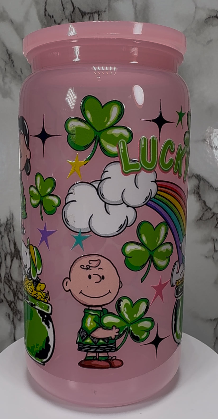 A Charlie Brown St. Patrick’s Day UVDTF on a pink PLASTIC beer can cup