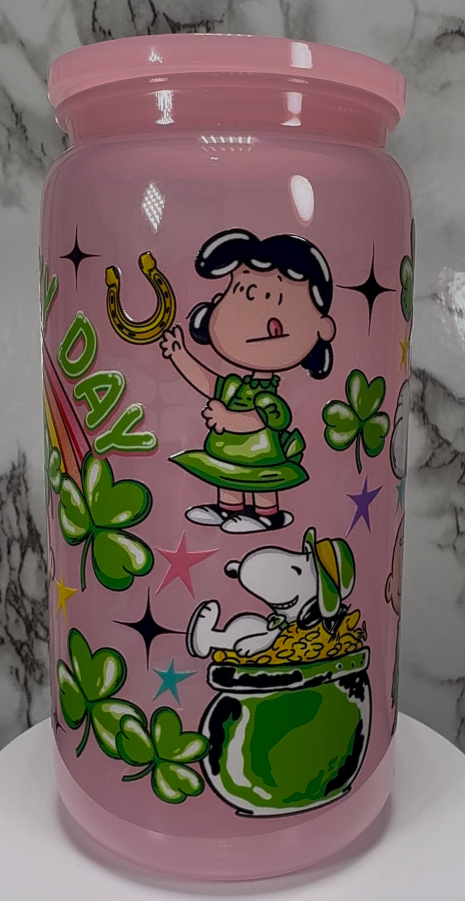 A Charlie Brown St. Patrick’s Day UVDTF on a pink PLASTIC beer can cup