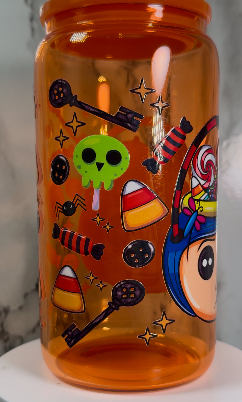Coraline & Other Mother Halloween Candy Buckets UVDTF on a orange beer can glass