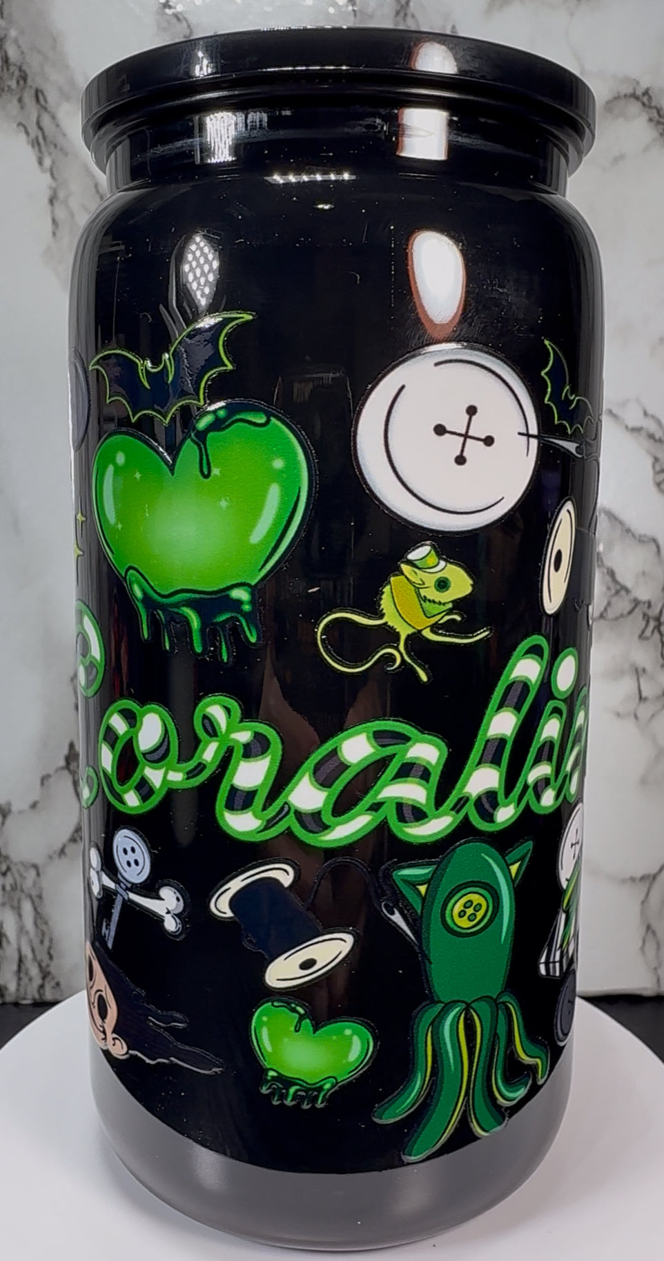 Coraline Green UVDTF on a black plastic beer can cup