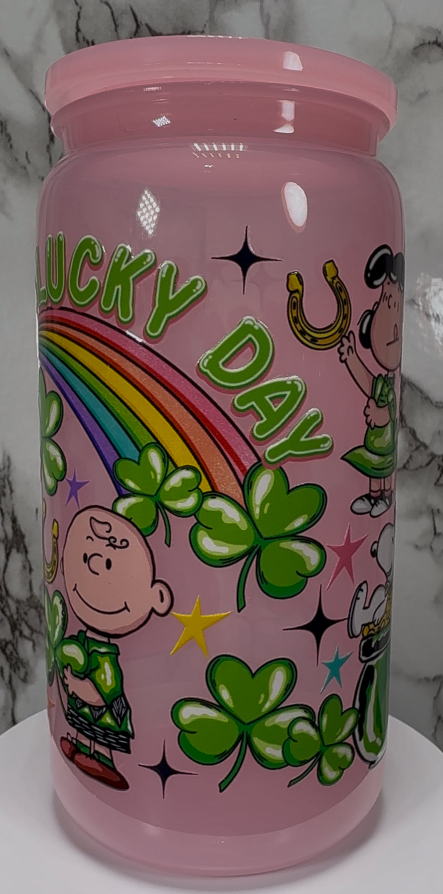 A Charlie Brown St. Patrick’s Day UVDTF on a pink PLASTIC beer can cup