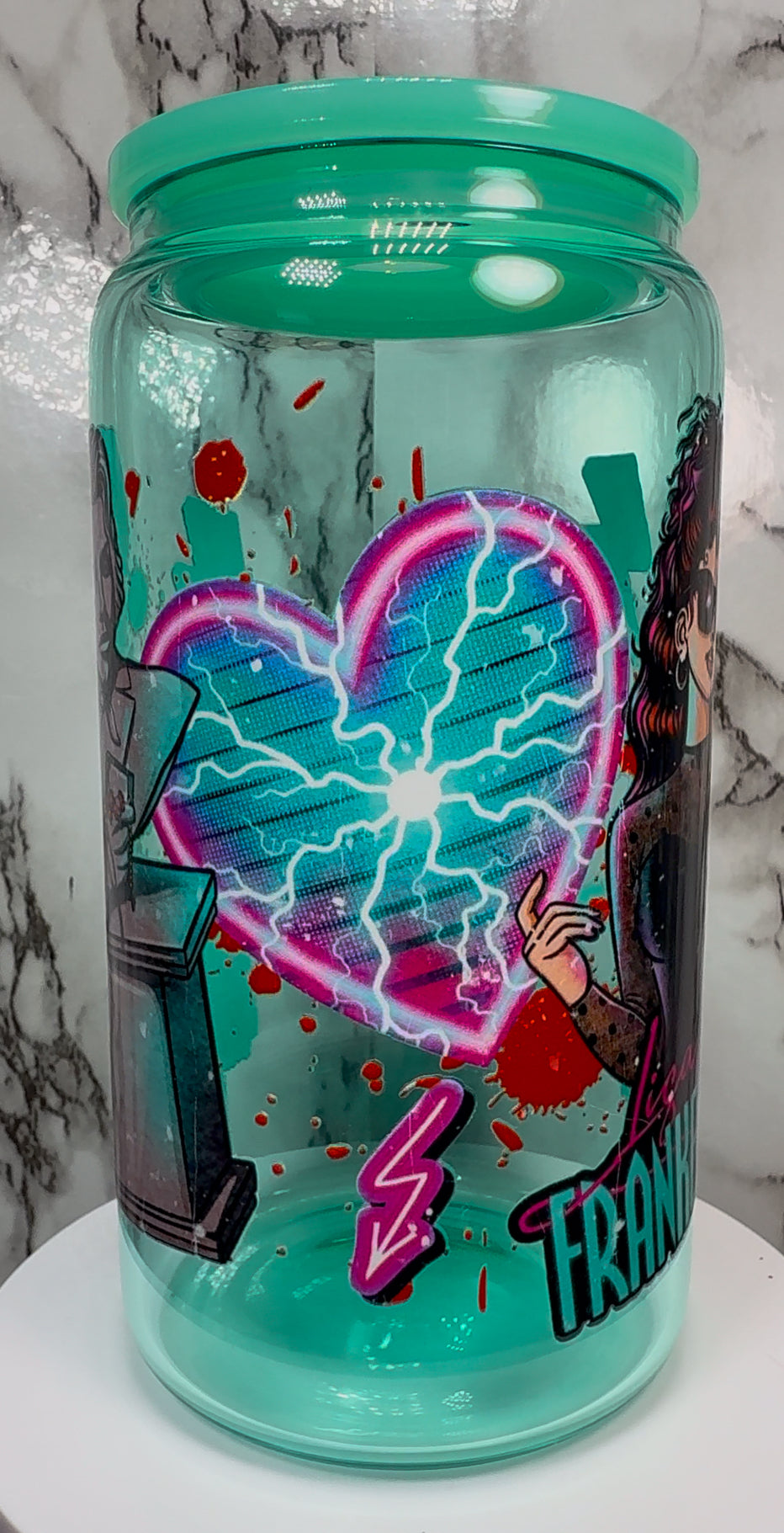 Lisa Frankenstein UVDTF on a teal beer can glass