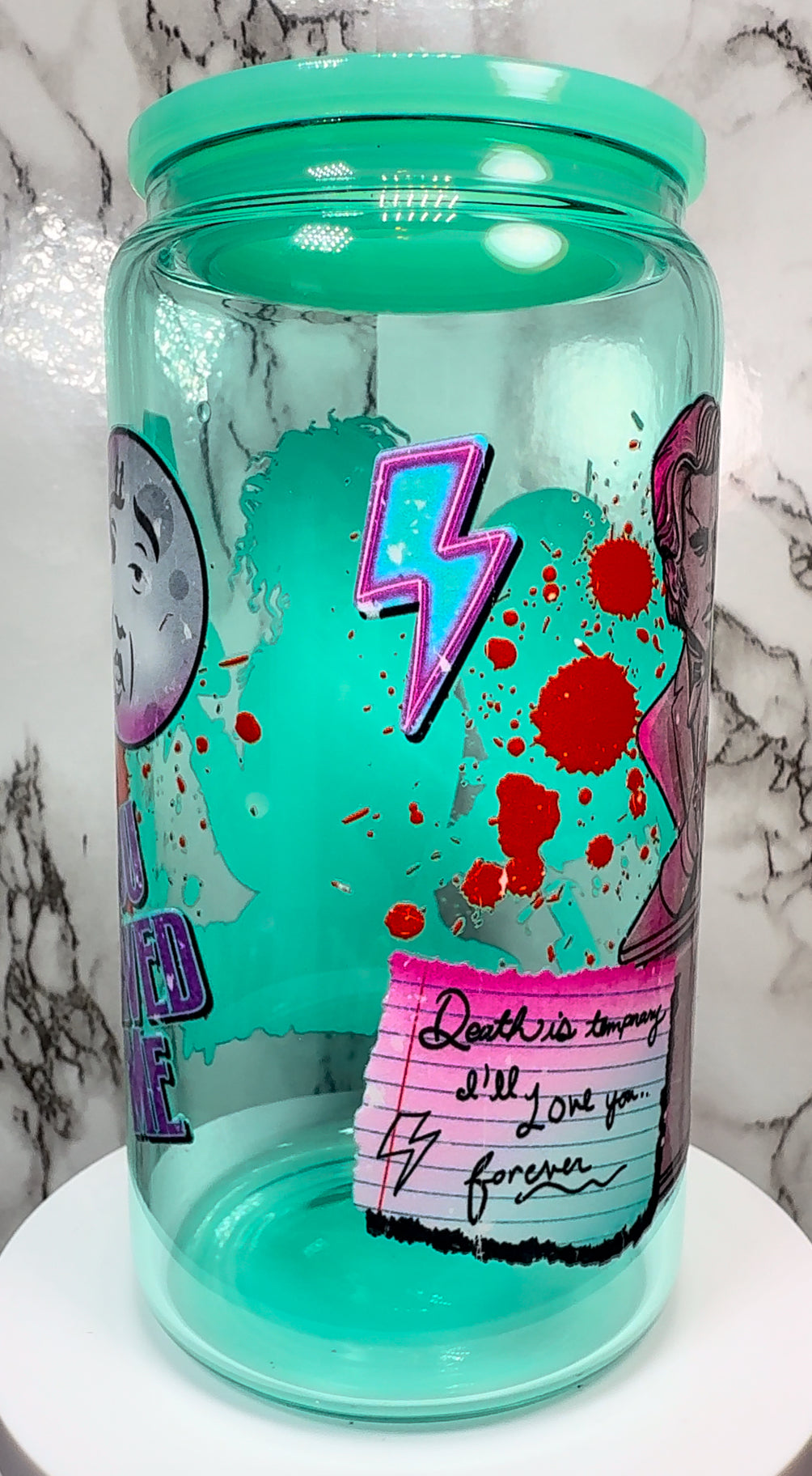 Lisa Frankenstein UVDTF on a teal beer can glass