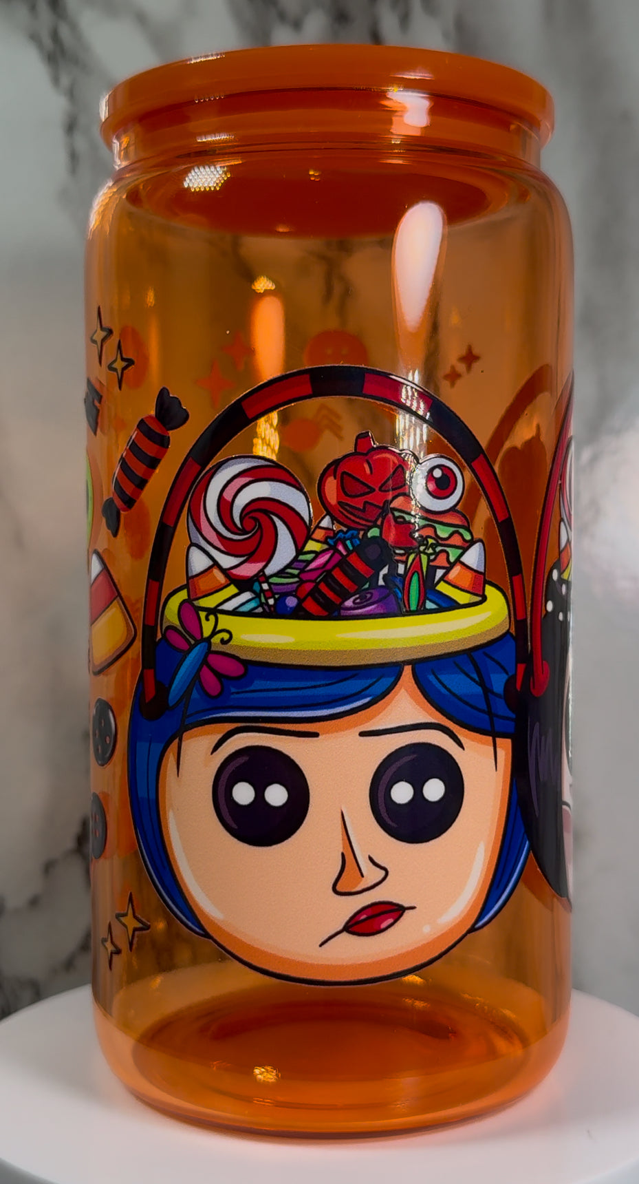 Coraline & Other Mother Halloween Candy Buckets UVDTF on a orange beer can glass