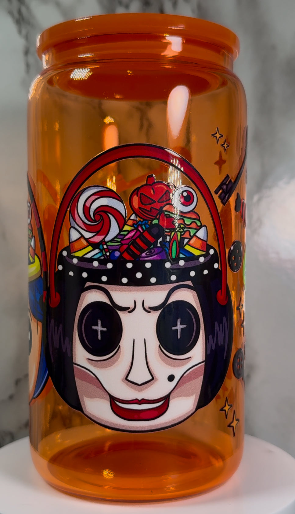 Coraline & Other Mother Halloween Candy Buckets UVDTF on a orange beer can glass