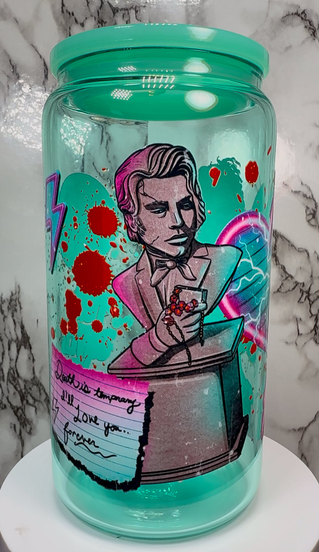 Lisa Frankenstein UVDTF on a teal beer can glass