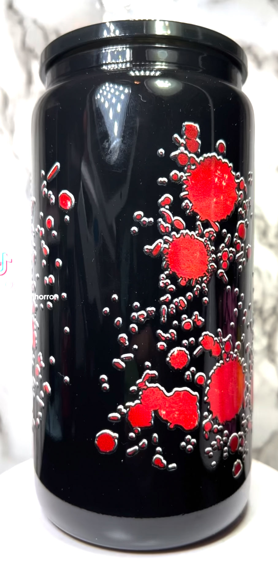 The Strangers UVDTF on a black beer can glass