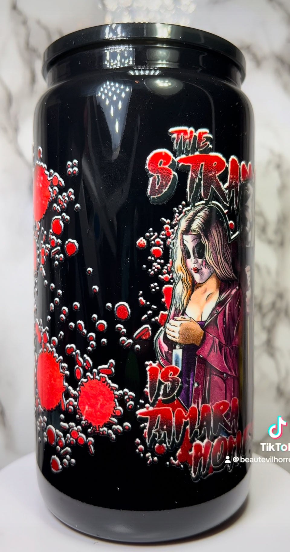 The Strangers UVDTF on a black beer can glass